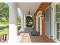 Inviting front porch with brick flooring, classic lanterns, and stately white columns at 506 Golfpark Dr, Celebration, FL 34747