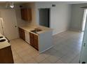 Cozy kitchen with tile floor, brown wood cabinets, and an adjacent living area at 5267 Images Cir # 102, Kissimmee, FL 34746