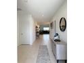 Bright hallway with sleek tile flooring, modern furnishings, and stylish decor, leading to the living areas at 542 Pine Tree Bridge Trl, St Cloud, FL 34772