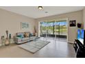 Comfortable living room with sliding glass doors leading to a screened lanai and water views at 6201 Goethe St # 103, Orlando, FL 32835
