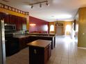 Bright, open kitchen with cherry cabinets, island, stainless steel appliances, and tile flooring at 7045 Branch Ct, St Cloud, FL 34771