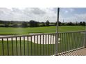 View from a screened-in patio overlooks a lush golf course with a sand trap in the distance at 725 Ocean Course Ave, Davenport, FL 33896