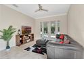 Living room features an entertainment center and a large leather couch, with doors opening to the backyard pool at 8439 Prestbury Dr, Orlando, FL 32832