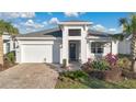A charming one-story home with a manicured lawn, beautiful landscaping, and a two-car garage at 891 Megano Blvd, Deland, FL 32724