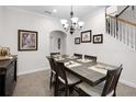 Formal dining room featuring a wooden table with seating for six, complemented by elegant decor and a stairway at 9104 Stromboli Ct, Kissimmee, FL 34747