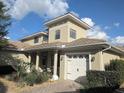 Charming two-story home featuring a barrel tile roof, manicured landscaping, and a brick-paved walkway leading to the entrance at 9104 Stromboli Ct, Kissimmee, FL 34747