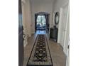 Inviting foyer with a dark rug and a glimpse into the living room, showcasing a seamless transition and warm atmosphere at 9104 Stromboli Ct, Kissimmee, FL 34747