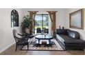 Cozy living room with elegant furniture, a decorative rug, and a view of the outdoor pool area at 9104 Stromboli Ct, Kissimmee, FL 34747