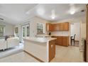 Open kitchen featuring an island with a sink, white countertops, and wood cabinetry adjacent to the Gathering room at 1016 Seminole Creek Dr, Oviedo, FL 32765