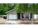 Charming single-story home featuring a garage and inviting front porch with seating at 10255 Cody Ln, Orlando, FL 32825