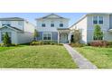Beautiful two-story home with green lawn and landscaped pathway to the front door at 10959 Vesper Aly, Orlando, FL 32829