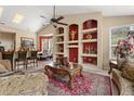 Open-concept living room boasts custom built-in shelves, high ceilings, and views into the dining area at 13609 Sky Blue Ct, Orlando, FL 32828