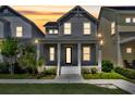 Charming two-story home at dusk featuring a welcoming front porch with classic columns and well-maintained landscaping at 13913 Hahn Ln, Orlando, FL 32827