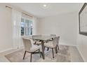 Cozy dining room featuring a modern table, soft lighting, neutral décor, and a large window at 1541 Tali Ln, Mount Dora, FL 32757