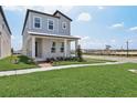 Well-maintained two-story home featuring a covered front porch, lawn, and landscaping at 16544 Silver Brook Way, Winter Garden, FL 34787