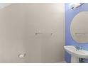Bathroom featuring a pedestal sink, oval mirror, and towel rack at 1774 Peterson Pl, Sanford, FL 32773