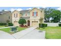 Two-story tan home with front yard landscaping and driveway leading to garage at 1774 Peterson Pl, Sanford, FL 32773