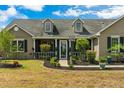 Inviting single-story home showcasing a charming porch with decorative landscaping and dormer windows at 19204 Paddock St, Orlando, FL 32833