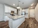 Spacious kitchen features white cabinets, stainless steel appliances, and a large center island with granite countertops at 2241 Mystic Maze Ln, Minneola, FL 34715