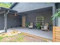 Inviting front porch with seating, ceiling fan, and stylish arched window, perfect for relaxing outdoors at 2415 S Oak Ave, Sanford, FL 32771