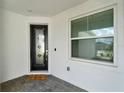 The front porch features a decorative glass front door and a window with privacy blinds at 2458 Cliff Way, St Cloud, FL 34771