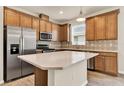 Modern kitchen with an island, stainless steel appliances, and wood cabinets at 2458 Cliff Way, St Cloud, FL 34771