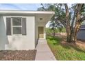 This single-story home has a covered front door area and a beautifully landscaped garden at 31830 Sybil Ave, Sorrento, FL 32776