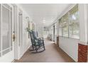 Inviting sun porch with rocking chairs, carpet floor, and an abundance of natural light through the windows at 40 W Smith St, Winter Garden, FL 34787