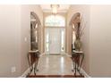 Bright foyer with tile flooring, decorative vases, and an arched transom window above the front door at 4201 Old Trafford Way, Orlando, FL 32810