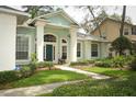 Inviting front exterior features a light blue facade, complemented by lush landscaping and walkway to the entrance at 4201 Old Trafford Way, Orlando, FL 32810