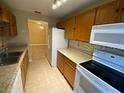 Practical kitchen includes wood cabinets, laminate counters, white appliances, and tile floors at 440 Martigues Dr, Kissimmee, FL 34759