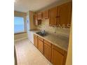 Functional kitchen featuring wood cabinets, laminate counters, and a double stainless steel sink at 440 Martigues Dr, Kissimmee, FL 34759