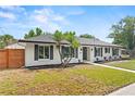 Lovely single-story home with manicured lawn, palms, dark shutters and a walkway to the front door at 4804 Oakbrooke Pl, Orlando, FL 32812