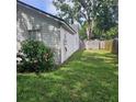 View of backyard space with healthy grass and a partial view of the home's siding at 5005 Mill Stream Rd, Ocoee, FL 34761