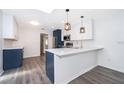 Bright kitchen with sleek two-tone cabinetry, stainless steel appliances, quartz countertops, and modern pendant lighting at 713 Coach Light Dr, Fern Park, FL 32730