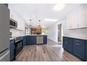 Modern kitchen featuring two-tone cabinets, stainless steel appliances, quartz countertops, and wood-look flooring at 713 Coach Light Dr, Fern Park, FL 32730