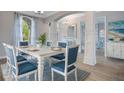 Bright dining room features a modern table with seating for six, elegant lighting and decor with a coastal vibe at 7978 Sea Pearl Cir, Kissimmee, FL 34747