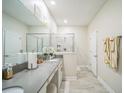 Bright bathroom featuring dual sinks, a large mirror, neutral paint, and a walk-in shower with glass door at 8907 Fallen Oak, Davenport, FL 33897