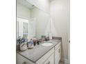 Modern bathroom featuring large mirror, single sink with stone countertop, and white cabinets at 8907 Fallen Oak, Davenport, FL 33897