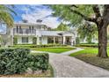 Beautiful two-story house showcasing manicured landscaping, balcony, and curved brick path at 940 Lincoln Cir, Winter Park, FL 32789