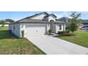 Well-manicured lawn complements the modern single Gathering home, complete with a two-car garage and inviting entrance at 1119 Union Ave, Mascotte, FL 34753