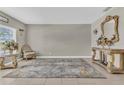 Neutral living room with elegant furnishings, including decorative mirror, chair, and decorative table at 116 Green Branch Blvd, Groveland, FL 34736