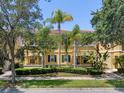 Beautiful yellow townhome with tropical landscaping, offering a serene and inviting curb appeal at 11918 Nautica Dr, Orlando, FL 32827