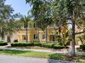 Charming yellow townhome with mature landscaping and palm trees in a well-maintained community at 11918 Nautica Dr, Orlando, FL 32827