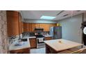 Open kitchen with stainless steel appliances, light countertops, an island with seating at 1302 Center St, Ocoee, FL 34761