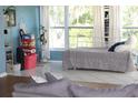 Light and airy bedroom with lots of natural light featuring a bed with gray covers and white curtains at 1364 Gainesville Dr, Deltona, FL 32725