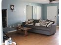 Cozy living room with comfortable seating, neutral decor, and laminate flooring at 1364 Gainesville Dr, Deltona, FL 32725