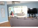View of the bedroom through a large open doorway, featuring a comfy gray couch and natural light at 1364 Gainesville Dr, Deltona, FL 32725