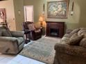 Comfortable living room showcasing cozy seating, an electric fireplace, and elegant wall decor at 1585 Stefan Cole Ln, Apopka, FL 32703