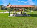 Covered picnic shelter with tables and trash cans near the playground and recreational area at 1684 Badger Creek Rd, Kissimmee, FL 34744